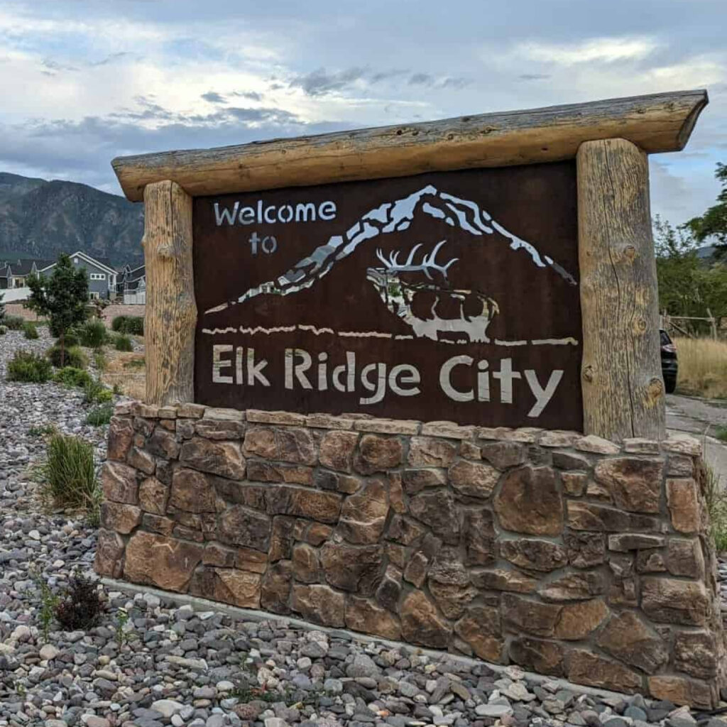 Elk Ridge City Utah welcome sign with stone base and mountains in the background for Water Damage Restoration Elk Ridge
